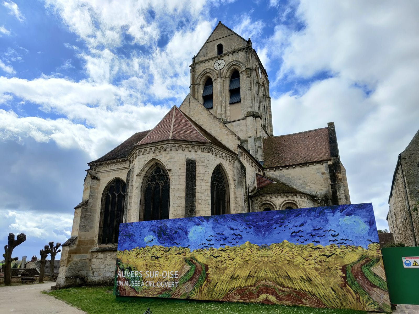 Die Kirche von Auvers-sur-Oise mit einer Reproduktion von Van Goghs Weizenfeld mit Krähen